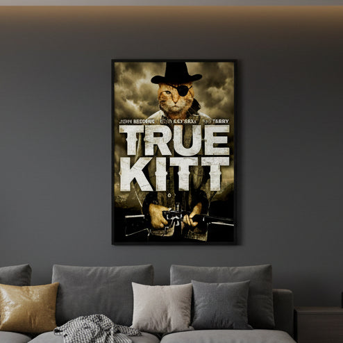 A cinematic movie poster parody titled 'True Kitt' featuring a rugged ginger tabby cat wearing a black cowboy hat and a black eye patch. The cat is shown in a close-up heroic pose against a vintage, textured parchment-style background. Based on the John Wayne Movie "True Grit" hung near an earthy toned couch with mismatched cushions.